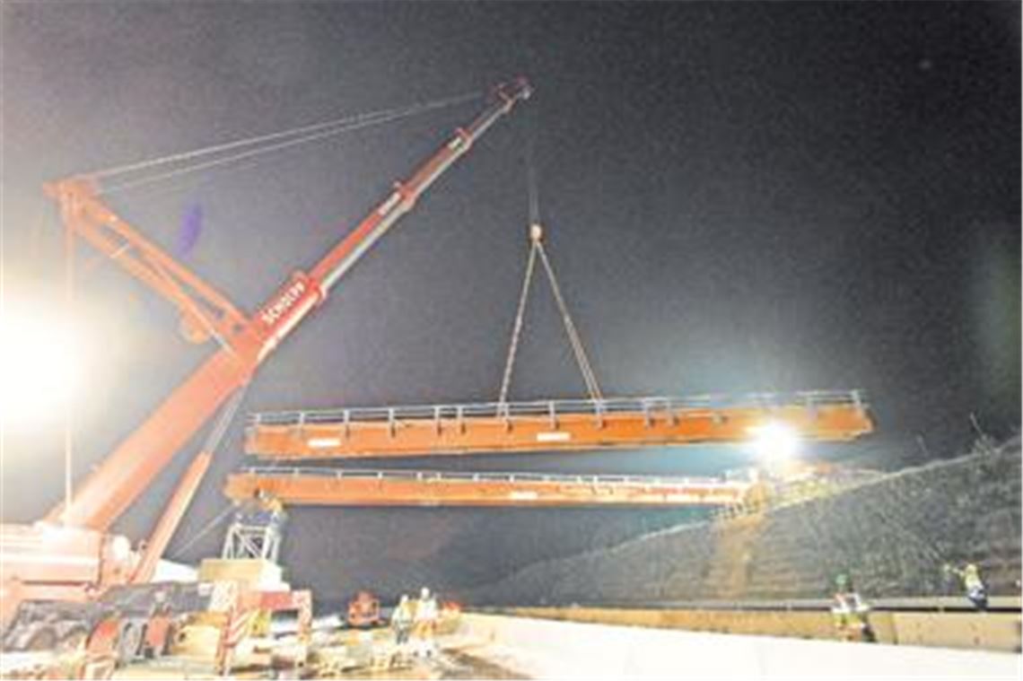 Schwerstarbeit im wahrsten Sinne des Wortes: Wuchtige Teile der Behelfsbrücke schweben am 650-Tonnen-Kran. Sie werden auf der gesperrten Autobahn abgelegt und dort auf die Transportmaße zerlegt. 
Foto: Tilo Keller