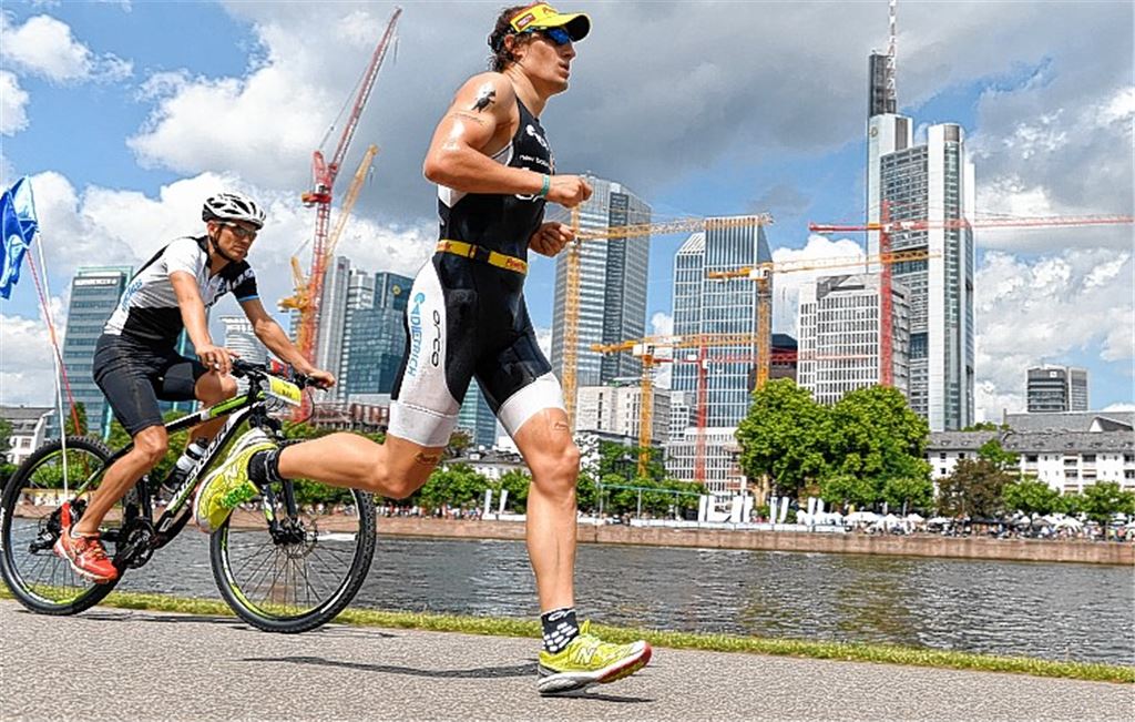 Sebastian Kienle vor der Skyline von Mainhatten. An seinem 30. Geburtstag gewinnt der Mühlackerer erstmals ein Langdistanz-Rennen und wird Europameister. Foto: dpa