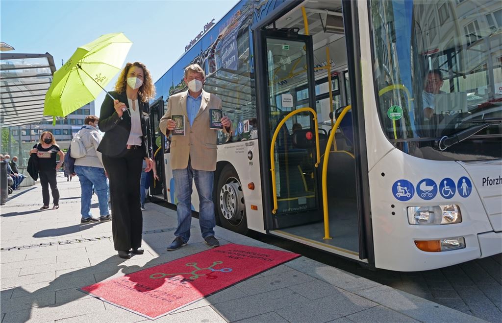 Selma Cantürk und Axel Hofsäß vom VPE lassen ihre Fahrgäste nicht im Regen stehen und rollen ihnen symbolisch den roten Teppich aus. Foto: Friedrich