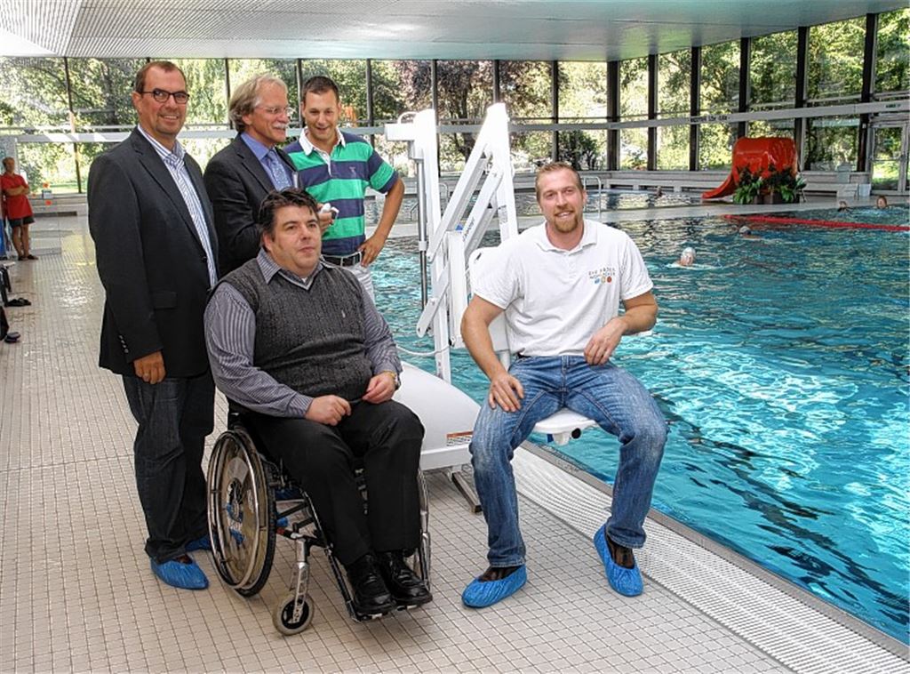 Sie präsentieren den frisch angeschafften Beckenlift (v. li.): OB Frank Schneider, Stadtwerke-Chef Jürgen Meeh, Berater Alexander Lang,SWM-Abteilungsleiter Frederik Trockel und Bäderbetriebsleiter Andreas Pfisterer. Rechtes Bild. Alexander Lang testet die neue Rollstuhlrampe. Fotos: Sadler