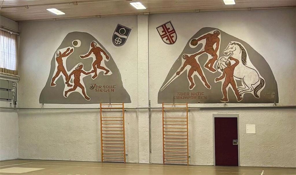 Siegen, aber nicht triumphieren: das Innenleben der 1937 eingeweihten und 1949 wiederaufgebauten Halle mit markantem Wandbild. Fotos: Schüller