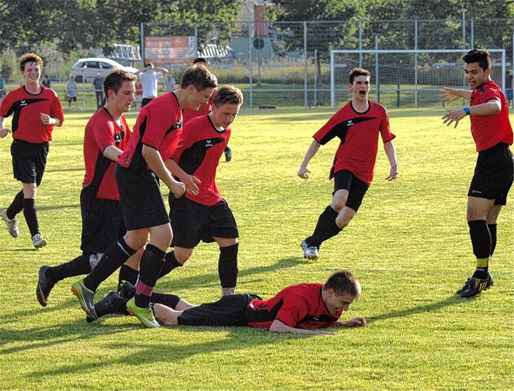 Siegtorschütze Cetin Topal liegt am Boden, seine Kameraden rennen auf ihn zu. Der Aufstieg in die Kreisliga Pforzheim ist endlich geschafft. Foto: Appich