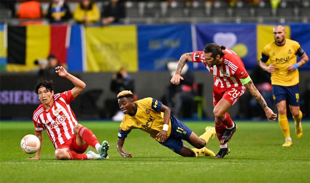 Simon Adingra (M) von Union SG kämpft um den Ball gegen Genki Haraguchi (l) von Union Berlin.