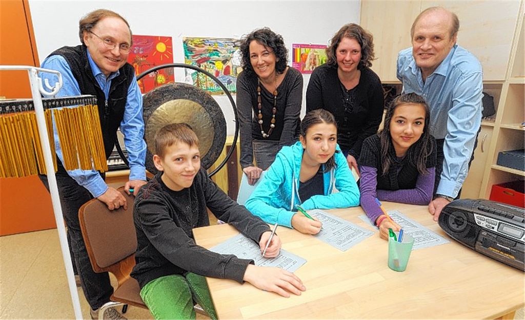 Sonija, Christina und Dustin sind beim Musik-Test im Kinderzentrum ganz Ohr. Ganz gespannt auf die Testergebnisse sind (hinten v.re.) Bernd Willimek, Kerstin Maier, Daniela Willimek und Professor Dr. Rainer Blank.