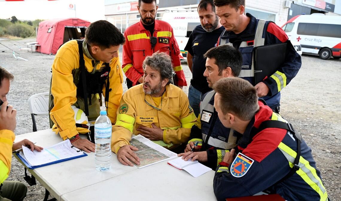 Tränen zum Abschied: Deutsche Feuerwehrleute auf Heimreise Spanische und aus Deutschland zur Hilfe geeilte Feuerwehrleute beraten bei dem Ort Jarilla über die Bekämpfung eines großen Waldbrandes. (Archivbild)