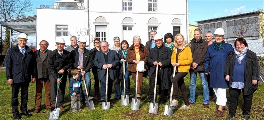 Spatenstich für die neue Kinderkrippe „Rabennest II“ in unmittelbarer Nachbarschaft des Ganztagskindergartens „Storchennest“ (im Hintergrund). Die Freude darüber teilt sich Oberbürgermeister Frank Schneider (3. v. li.) mit Mitgliedern der Stadtverwaltung, des Gemeinderats, des Betreibers „Rabennest“ und der Baufirma „Südwestbau“ aus Pforzheim.