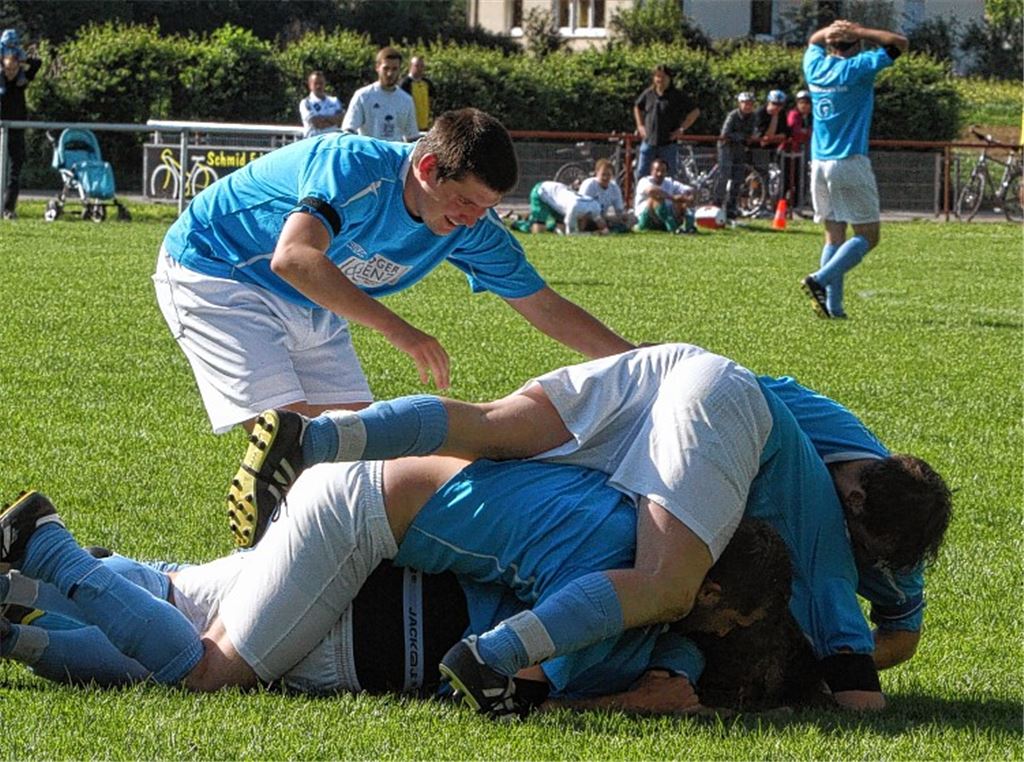 Spiegelbild einer seltsamen Seelenlage: Vorne feiern fünf Mühlhäuser Spieler das 3:2 von Serdar Kurt – er liegt ganz unten im Knäuel – und im Hintergrund kann Dirk Weis den Siegtreffer in der letzten Sekunde der Nachspielzeit selbst kaum fassen. Foto: Eigner