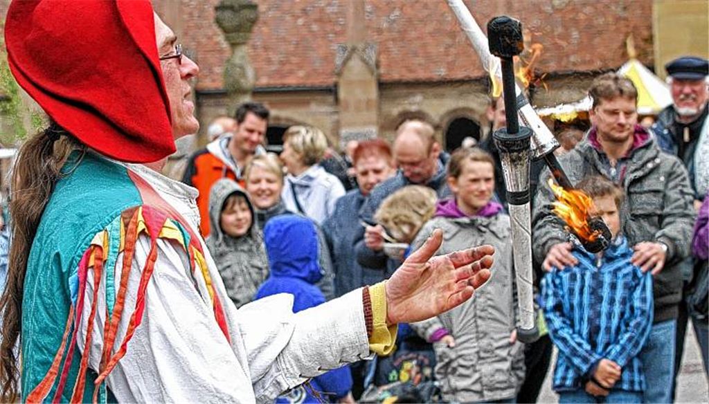Spiel mit dem Feuer: Magier Tumalon alias Frank Pfetzing jongliert, und die Besucher des Markts im Maulbronner Klosterhof haben ihren Spaß.