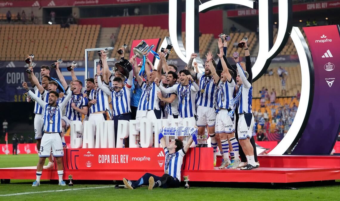 Spieler von Real Sociedad feiern mit dem Pokal.