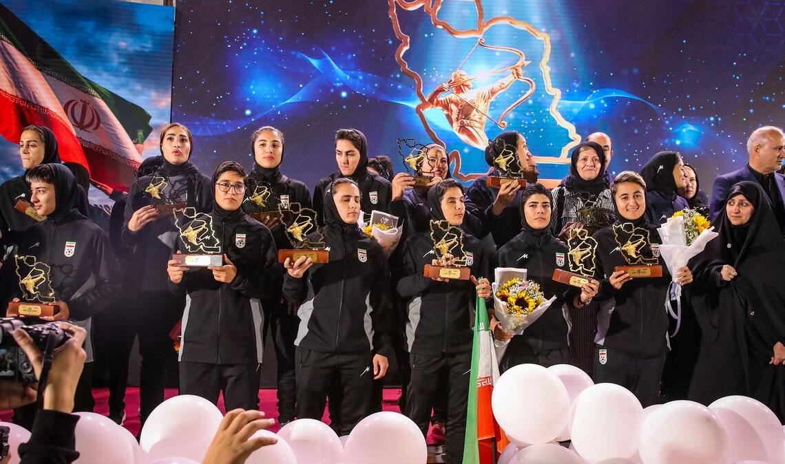 Spielerinnen der iranischen Fußball-Nationalmannschaft stehen auf einer Bühne in Teheran, während einer Empfangszeremonie nach ihrer Teilnahme am AFC Women's Asian Cup in Australien.