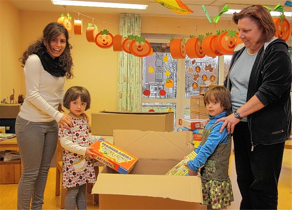 Spielsachen werden in einen Umzugskarton gelegt. Unser Bild zeigt Kinder zusammen mit der Kinderpflegerin Angela Bonsignore (li.) und Kindergartenleiterin Barbara Fix. Der Kindergarten „Schwalbennest“ war bisher in einem angemieteten Gebäude in den Herrschaftsgärten untergebracht. Fotos: Franz