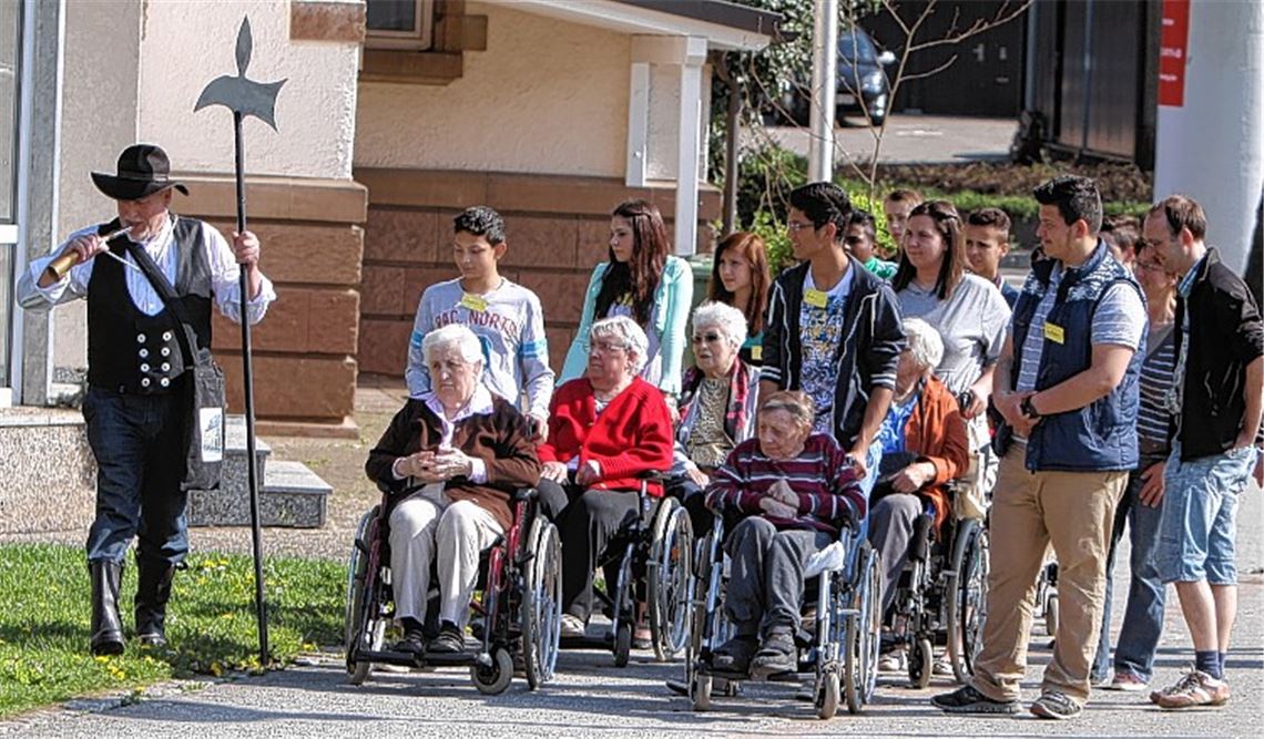 Stadtführer Rainer Wallinger stößt ins Horn: Nach dem Aufbruchsignal macht sich ein Tross von Schillerschülern und Senioren aus dem St. Franziskus auf den Weg durch Dürrmenz. 
