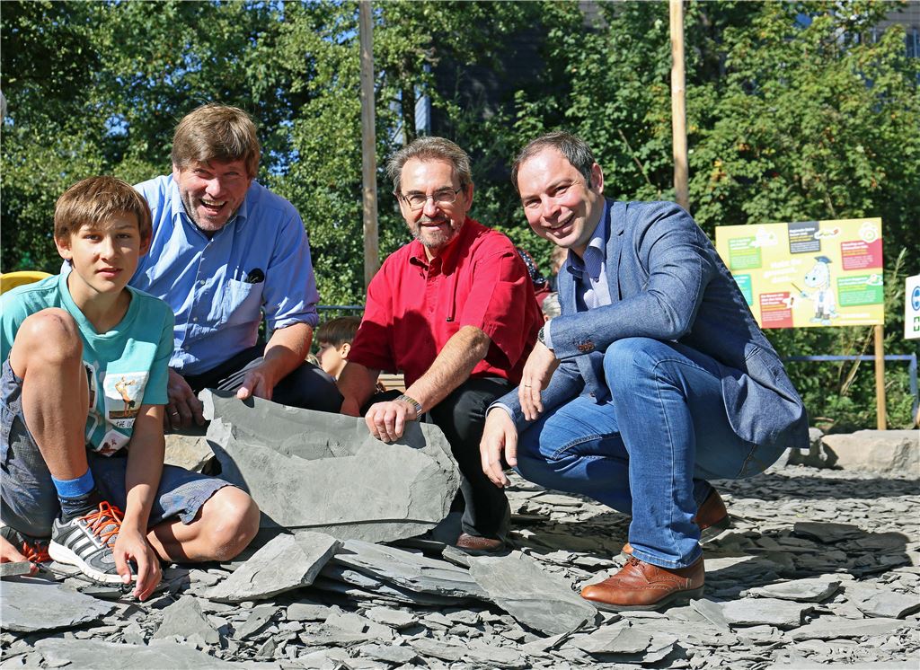 Steinbruch-Chef Jochen Sämann zeigt Heinz Sprenger, stellvertretender Geschäftsführer des Industrieverbands Steine und Erden, sowie dem grünen Landtagsabgeordneten Markus Rösler und seinem Sohn David (v. re.) den Klopfplatz der Firma Sämann Stein und Kies in den Enzgärten. Über 100 Tonnen Schiefer sind dort an den mittlerweile fast 128 Gartenschautagen zerkleinert worden.  Foto: Goertz