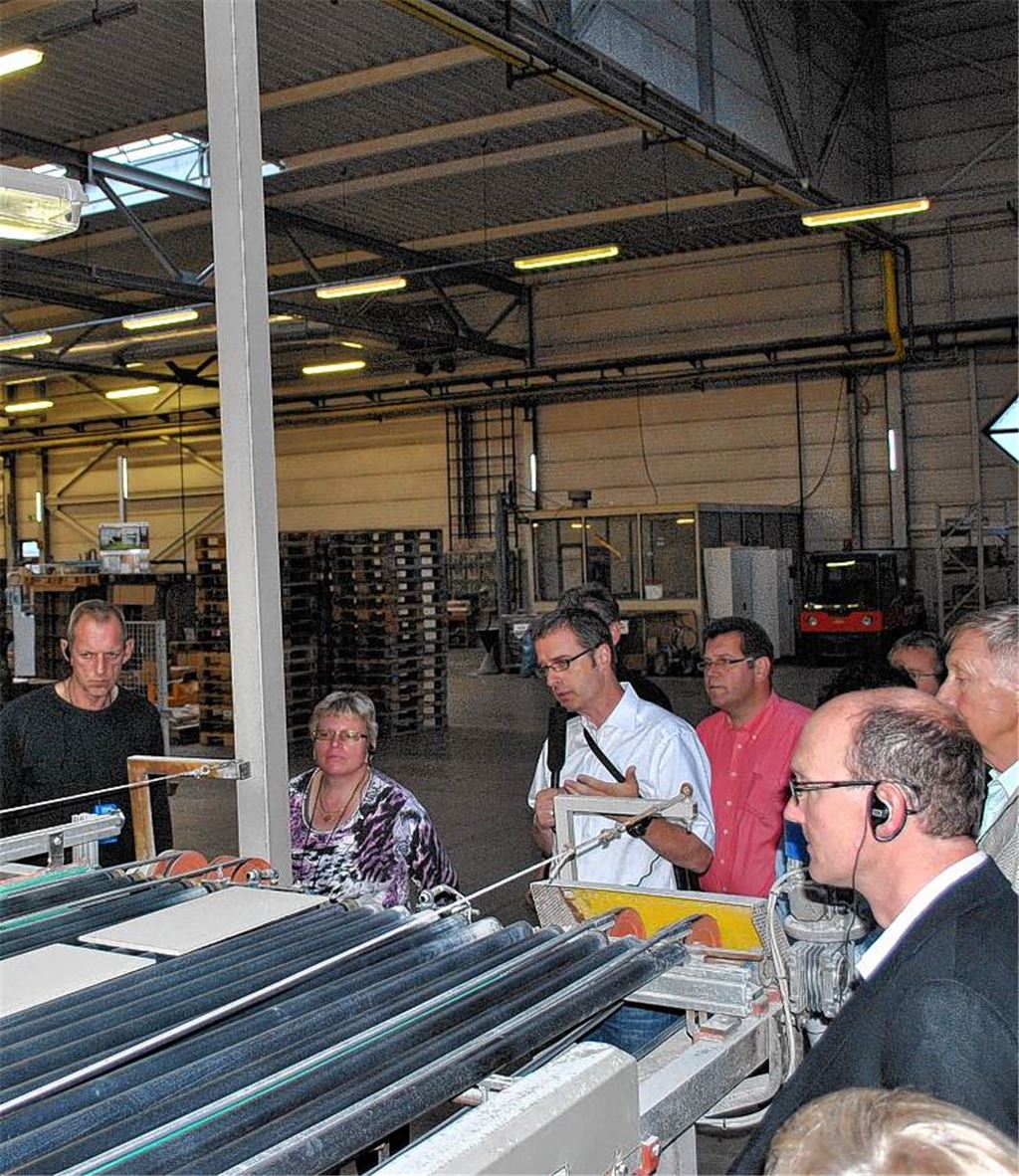 Steuler-Geschäftsführer Klaus-Martin Andreas (im weißen Hemd) führt die Gäste durch die Fliesenproduktion.