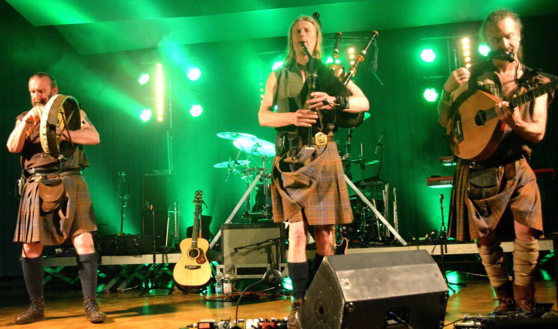 Stilecht: Irisch-grüne Ausleuchtung der Bühne und kernig ausschauende Männer in Röcken. Und natürlich gibt es zur Musik von der Insel auch Guiness und Whisky. Fotos: Stahlfeld