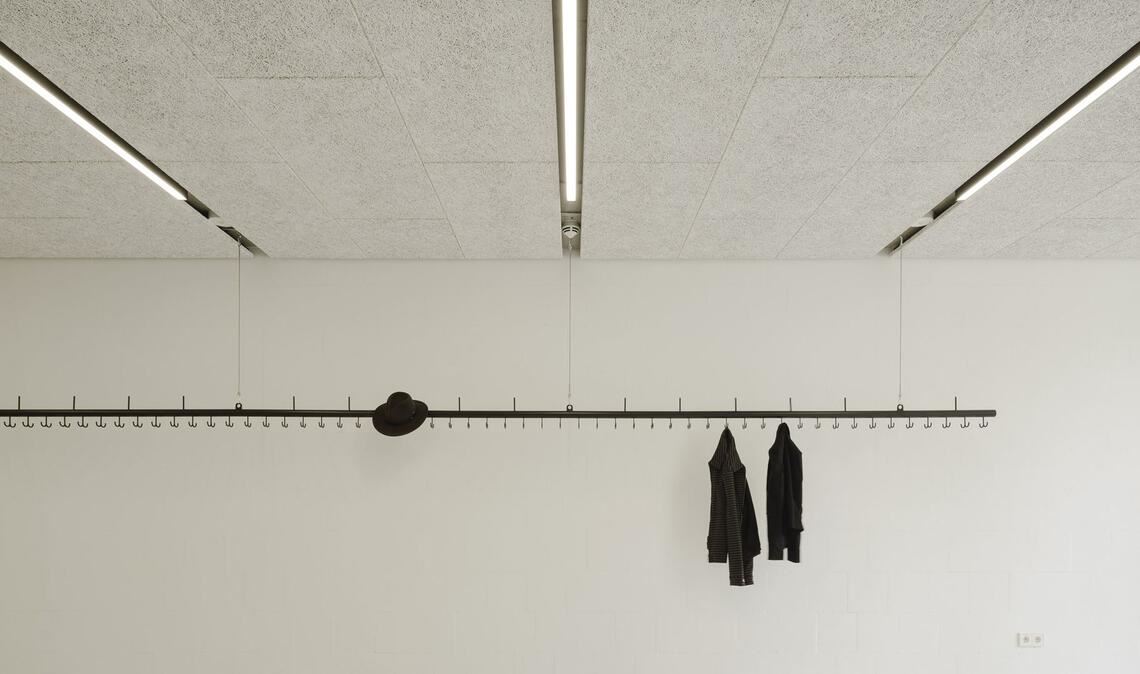 Stilvoll bis ins Detail: Die vom Büro Atelier Kaiser Shen selbst entworfene Garderobenstange, die im Eingangsbereich von der Decke hängt, könnte auch bei einer Ausstellung fürs Bilderaufhängen verwendet werden.