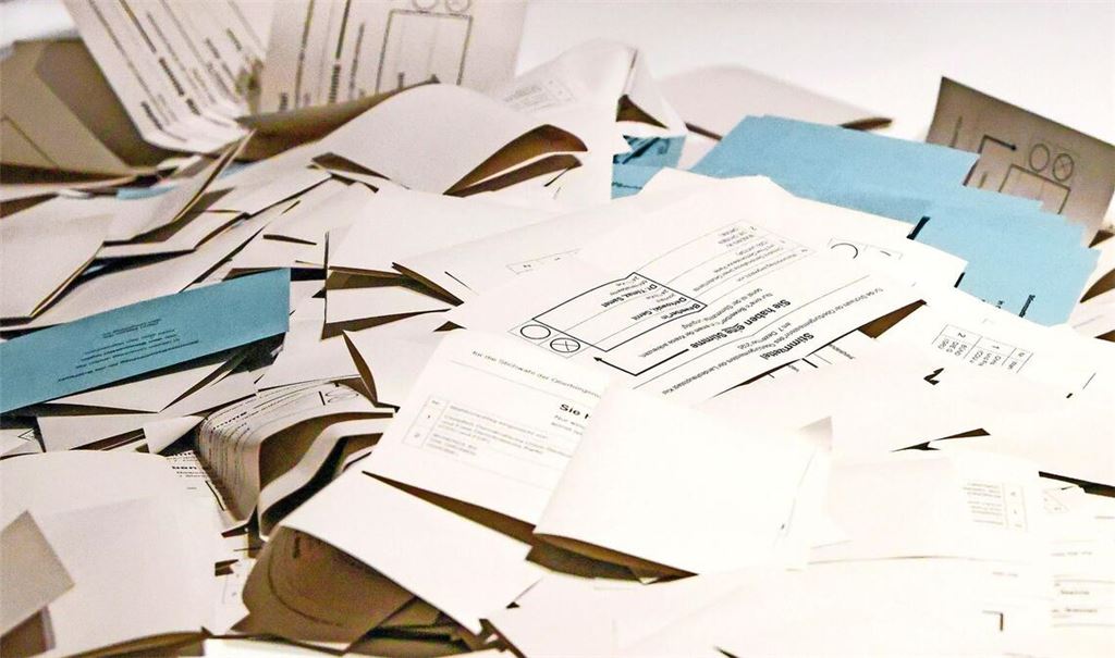 Stimmzettel liegen auf einem Tisch in einem Wahllokal.