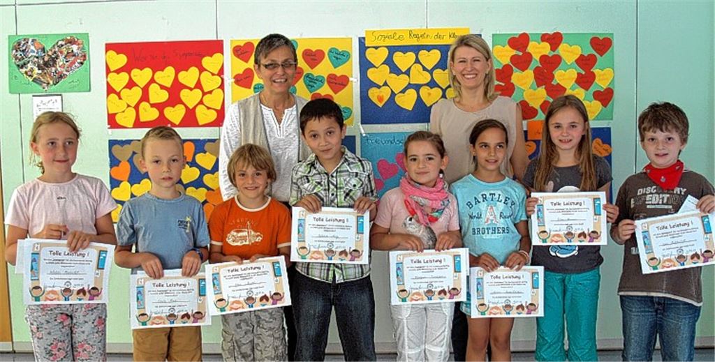 Stolz auf ihren Preis, der mit einem Gutschein für ein Spielwarengeschäft verbunden ist: Zum ersten Mal hat die Schiller-Grundschule speziell das soziale Verhalten der Schüler ab Klasse zwei belohnt. Rektorin Waltraud Schellenberger-Hagenbucher (hinten li.) und Schulsozialarbeiterin Lidia Kirschner überreichen die Auszeichnungen.
