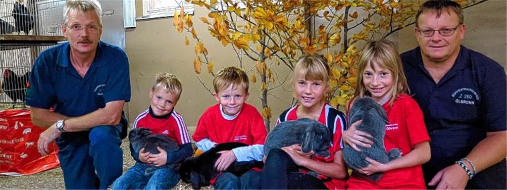 Stolz sind die Vereinsvorsitzenden Michael Grausam (li.) und Jürgen Braun über die jungen Züchter im Verein (v. li.): Colin Weihing mit einem „Farbenzwerg“, Julian Braun mit einem Zwergwidder schwarz und Celine und Carina Braun mit Kaninchen der Rasse Zwergwidder blau.