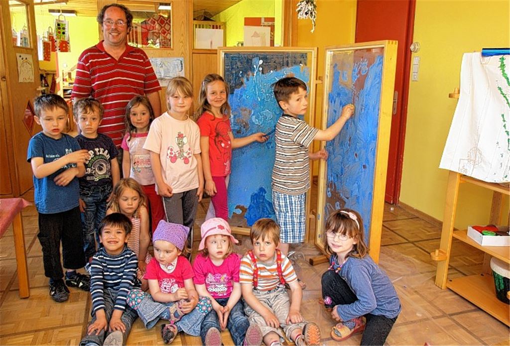Stolz stellen die Kinder des Friedrich-Münch-Kindergartens mit Glasermeister Matthias Trück ihre neuen durchsichtigen Staffeleien vor. Foto: Appich