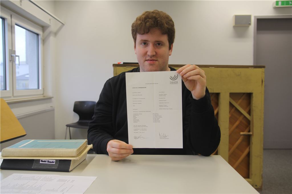 Studierauftrag: So heißt das wichtige Dokument, das Mino Marani der Kamera präsentiert. Dort ist nicht nur festgehalten, wer welche Rolle spielt, sondern auch wann die Proben beginnen.  Foto: Becker