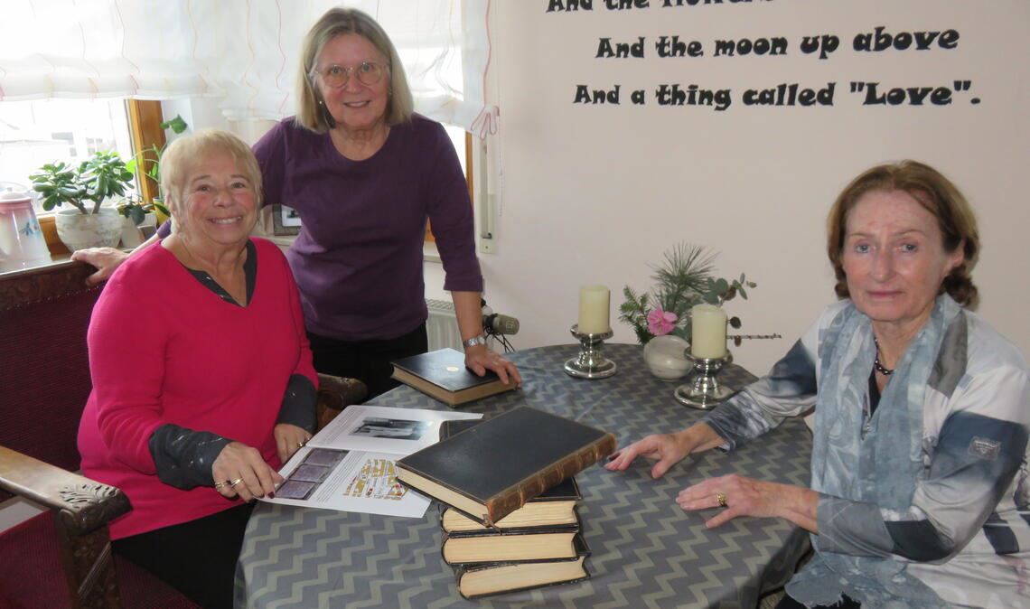 Susan Walker (li.) bei einem Besuch in Mühlacker, wo ihre Familie bedeutende Spuren hinterlassen hat. Die Großnichte des jüdischen Fabrikanten Alfred Emrich blättert hier, zu Gast bei ihrer Freundin Helga Emmerich (Mitte), in einer Broschüre über ihre Familie. Den Kontakt zwischen beiden Frauen hergestellt hat Angela Dettinger aus Pforzheim (re.). Foto: Becker