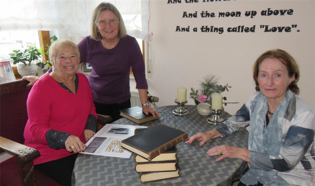 Susan Walker (li.) bei einem Besuch in Mühlacker, wo ihre Familie bedeutende Spuren hinterlassen hat. Die Großnichte des jüdischen Fabrikanten Alfred Emrich blättert hier, zu Gast bei ihrer Freundin Helga Emmerich (Mitte), in einer Broschüre über ihre Familie. Den Kontakt zwischen beiden Frauen hergestellt hat Angela Dettinger aus Pforzheim (re.). Foto: Becker