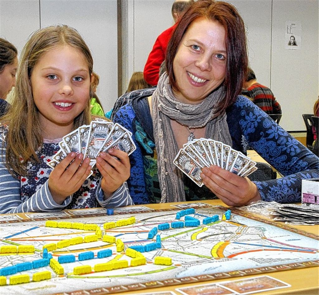 Susanne Pickel und ihre Tochter Juli spielen „Zug um Zug“ aus, wer am besten das Eisenbahn-Schienennetz ausbaut.