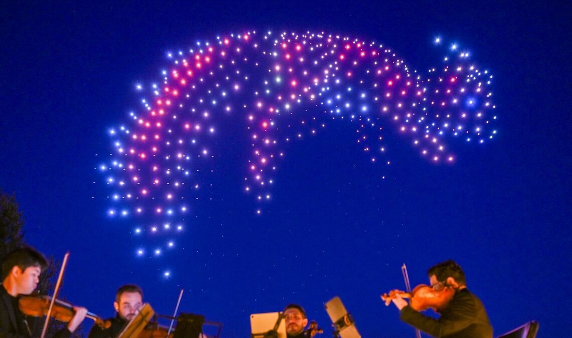 Sychronisierte Drohnen formen bei einer DroneArt Show Lichtbilder am Himmel über den Gärten der Welt in Berlin.