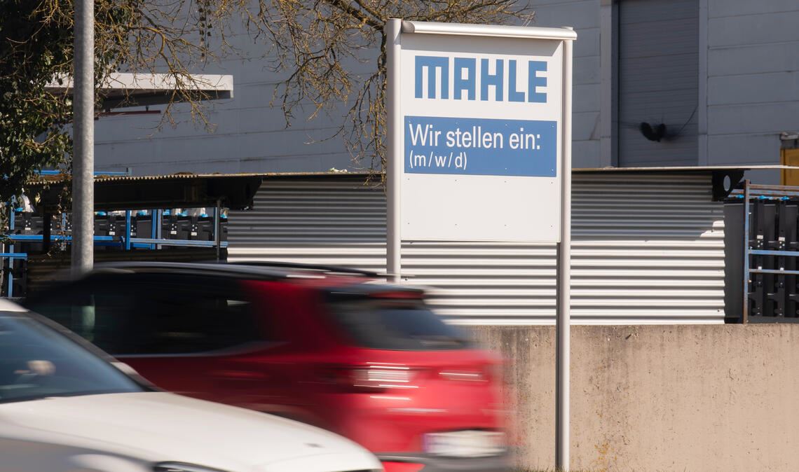 Symbolträchtiges Schild beim Mahle-Werk in Mühlacker. Das Unternehmen stellt ein – bloß wen? Die Transformation ist an der Lienzinger Straße, wo schwerpunktmäßig Komponenten für Verbrennermotoren hergestellt werden, voll im Gange. Der Personalabbau setzt sich fort, gleichzeitig investiert Mahle in Ausbildung. Die Lage ist unübersichtlich. Foto: Fotomoment