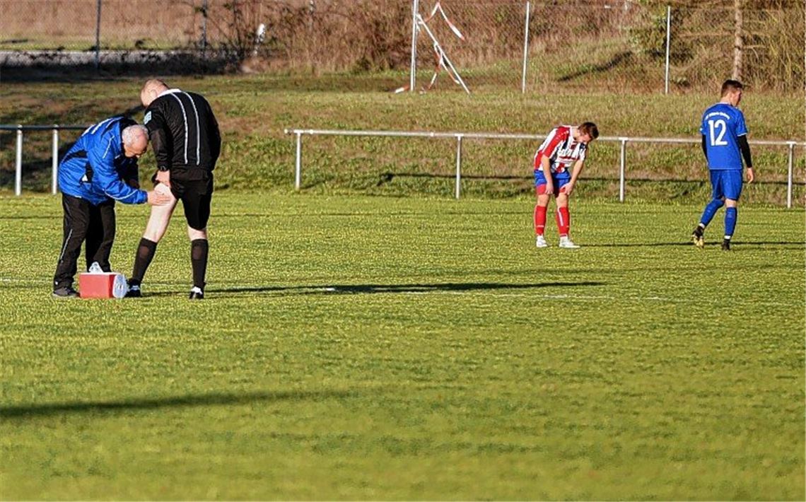 Keller-Duell endet in der Halbzeit TSV-Betreuer Bernd Jung behandelt Schiedsrichter Jürgen Weber,der sich im Spiel zwischen Ötisheim und Enzberg am linken Oberschenkel verletzt.Fotos: Huber