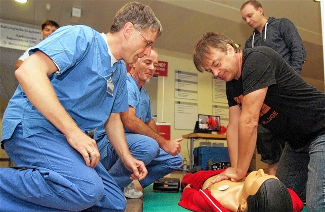 Tag der Wiederbelebung: Dr. Stefan Bosch und Joachim Hund schulen Besucher wie Fernando de Vito und Dieter Eisenbeiß (v. li.) in der Herzdruckmassage.