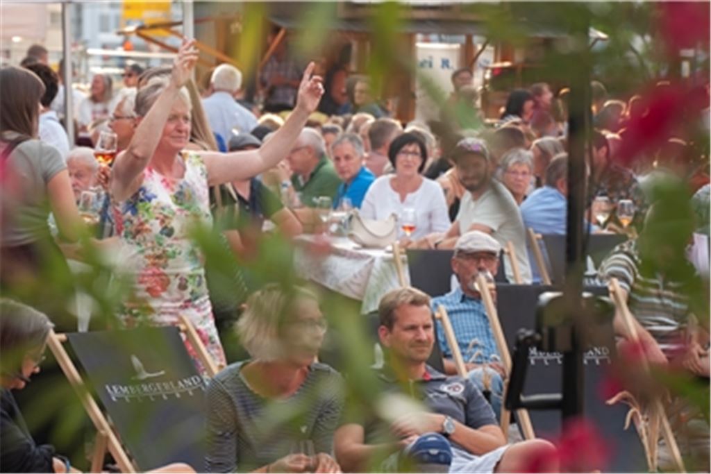 Tanzen, trinken und plaudern: Bei einem Gläschen Wein lassen die Besucher des Weinfests den Freitagabend in gemütlicher Stimmung ausklingen. Foto: Fotomoment