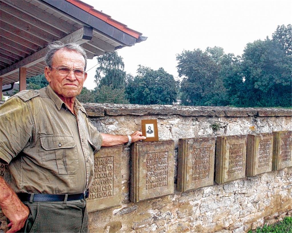 Teil der Familiengeschichte: Walter Schmierer senior vor den Gedenktafeln, die auf dem Mühlhäuser Friedhof an die Opfer der Mordnacht vor 100 Jahren erinnern. Einer der Namen ist der des Onkels, den Walter Schmierer nur vom Foto kennt. Jakob Schmierer starb mit 42 Jahren.