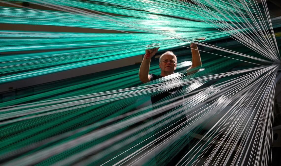 Bilder des Tages Textile Skipisten aus Chemnitz - In der Produktion von Mr. Snow in Chemnitz arbeitet Web-Meister Mario Thümer an einer Webmaschine für textile Gleitmatten.