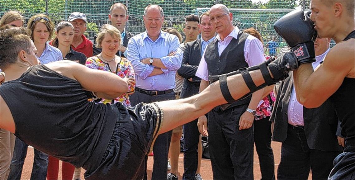 „Thaiboxen ist wie Wahlkampf“, macht Uwe Hück (schwarze Weste) dem SPD-Kanzlerkandidaten Peer Steinbrück (helles Hemd) und Katja Mast (bunte Bluse) seine Sportart schmackhaft. Foto: Eigner
