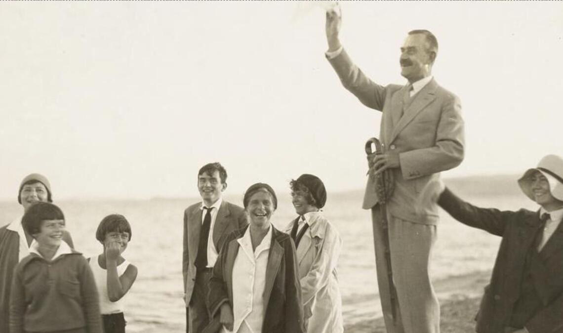 Thomas Mann hält am Strand eine kleine Volksrede – unter den Zuhörern (von links:) Ilse Dernburg, Elisabeth Mann, Michael Mann, Golo Mann, Ehefrau Katia Mann, Monika Mann, sowie rechts von ihm eine Unbekannte