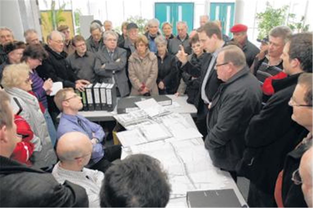 Thomas Weick (sitzend, im blauen Hemd) vom Regierungspräsidium Karlsruhe und Arnd Heiderer (re. daneben) vom Ingenieurbüro Thomas und Partner stellen sich den Fragen der Bevölkerung. Im Bild richtet gerade Gemeinderat und MdB Erik Schweickert Fragen an die Experten.
Foto: Keller