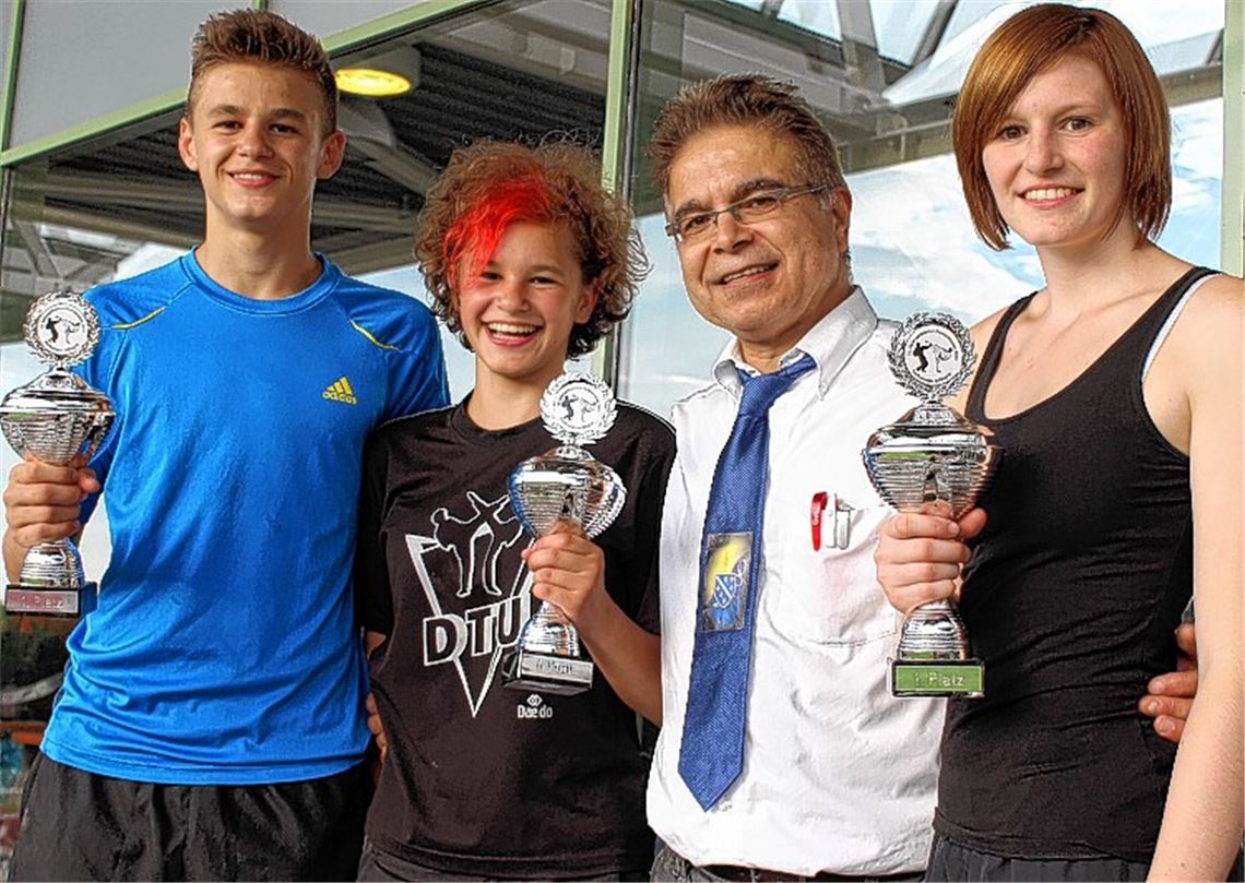 Timo, Riccarda und Tamara Nothaft (v.li., mit Kampfrichter und Trainer Ibrahim Sönmezates) freuen sich über ihre Turniersiege. Foto: privat