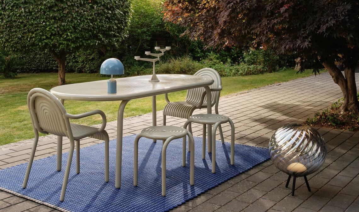 Ton-in-Ton-Streifen. Der Rillenlook von Tisch, Hocker und Sessel von Tom Dixons erster Outdoor-Kollektion passt zum Teppich, der aus 100 Prozent recyceltem Material besteht.