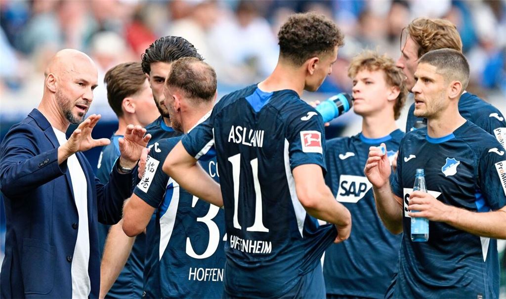 Trainer Christian Ilzer (l, 1899 Hoffenheim) spricht mit seinen Spielern. Für Hoffenheim ist das Rennen um einen Champions-League-Platz noch nicht vorbei.