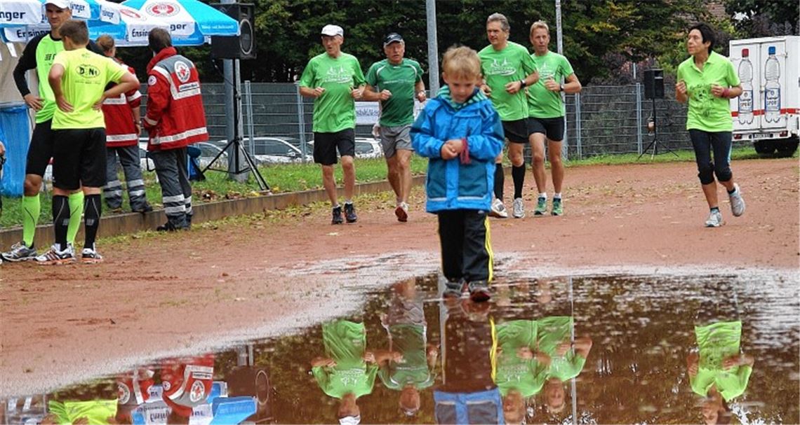 Trotz Nässe ziehen Läufer für den guten Zweck ihre Runden auf der Laufbahn.