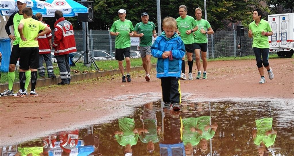 Trotz Nässe ziehen Läufer für den guten Zweck ihre Runden auf der Laufbahn.