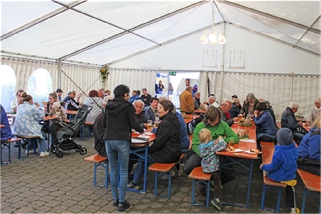 Trotz herbstlicher Witterung ist das traditionelle Wein- und Backhausfest in Schönenberg, wo Bernd Beuchle am Ofen für Nachschub sorgt (Foto unten), gut besucht. Fotos: Gießler