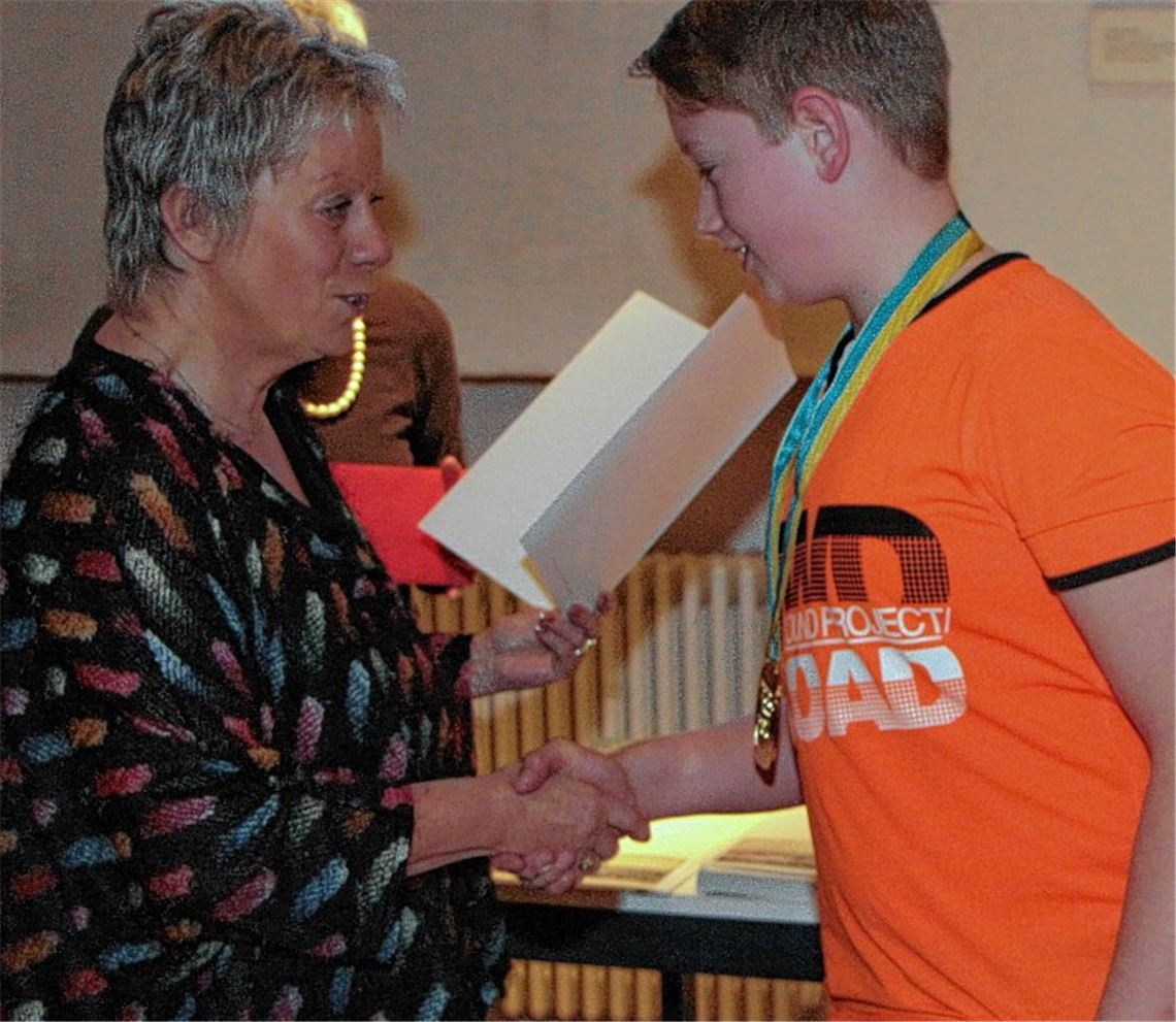 Turngau-Ppräsidentin Bärbel Vorrink händigt Bogenschütze Kevin Allenstein die Urkunde aus.