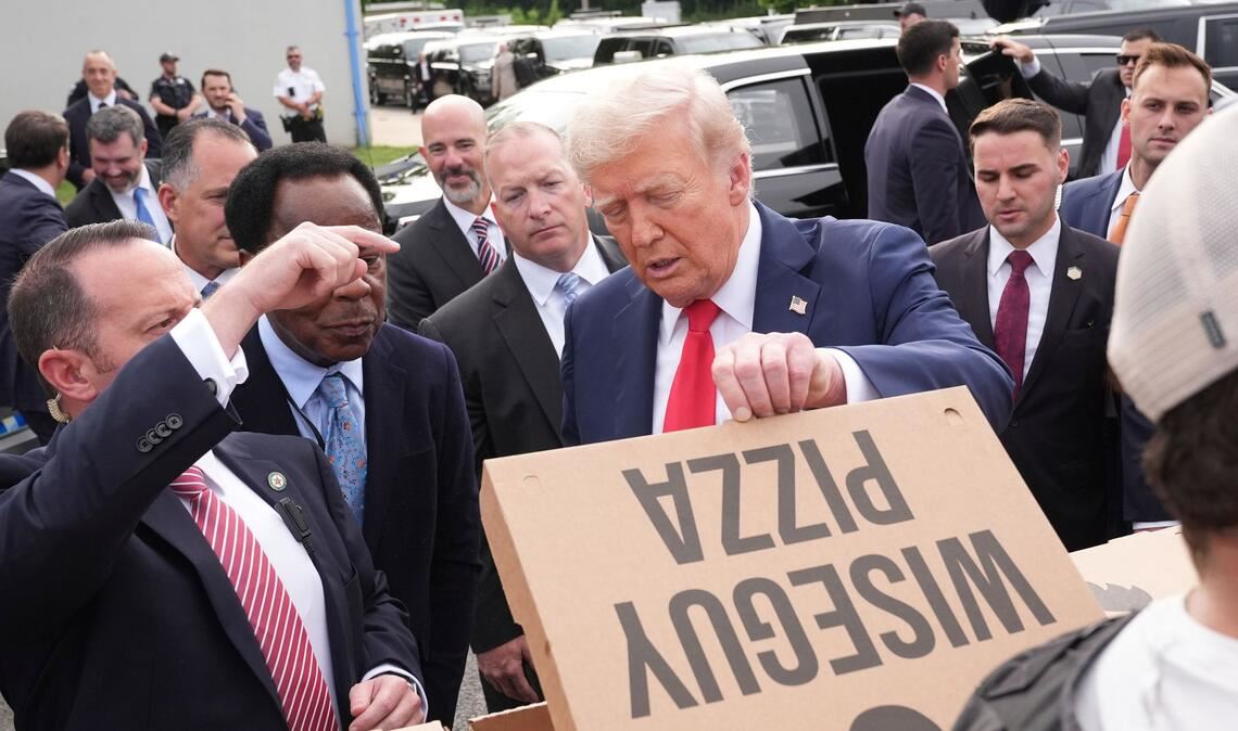 US-Präsident Donald Trump schaut sich eine Pizza an, während er sich mit Mitgliedern von Strafverfolgungsbehörden und Soldaten der Nationalgarde in Washington trifft.