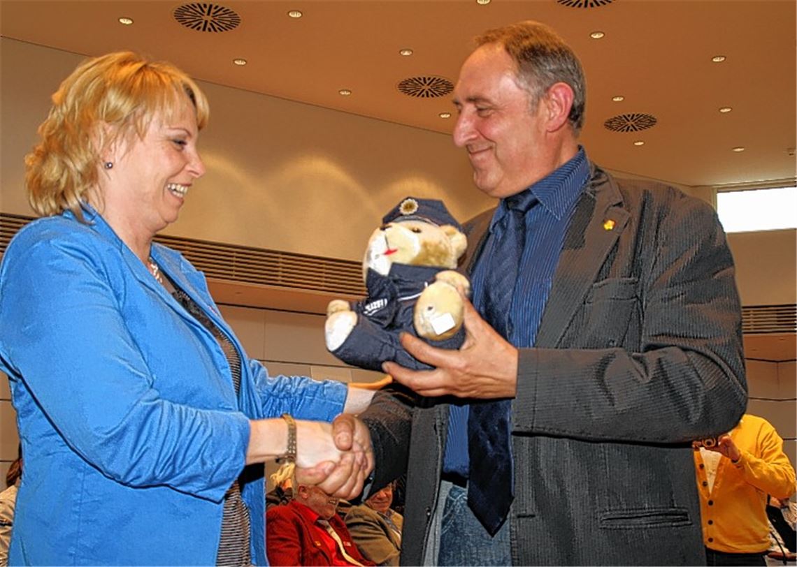 Udo Hampel, Vorsitzender der Personalvertretung der Polizeidirektion Pforzheim und DGB-Vorstandsmitglied, überreicht Gewerkschaftssekretärin Susanne Nittel den Ehrenteddybär in Polizeiuniform. Foto: Günther
