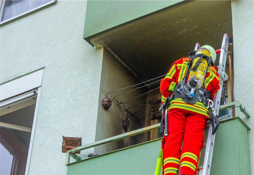 Über die Steckleiter bekämpft die Feuerwehr den Brand auf dem Balkon.Einsatz 24