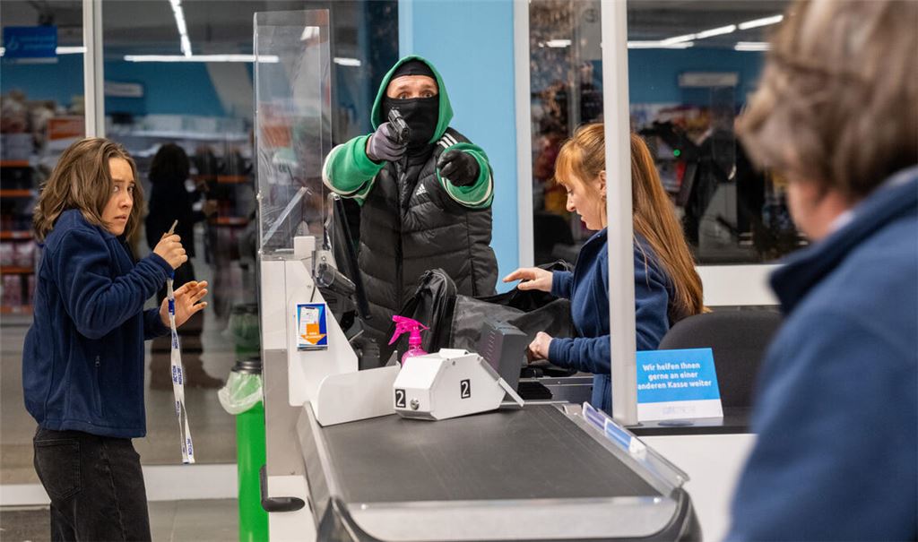 Überfall auf einen Discounter. Der Täter im grünen Jogginganzug bedroht die Angestellten. Doch dann stören Zeugen die Tat.