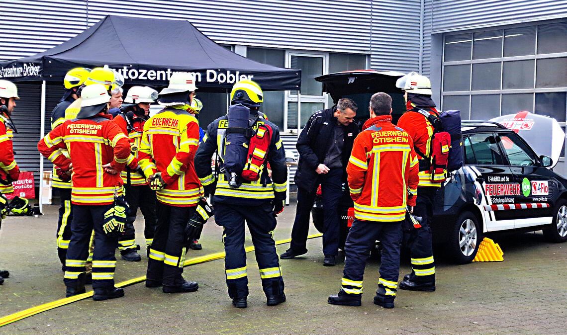 Mit Abstand den Stromschlag vermeiden Übungseinheit der besonderen Art: Bei einer Schulung werden den Vertretern der Feuerwehr die wichtigsten (Sicherheits-)Regeln im Umgang mit E-Autos vermittelt. Foto: Friedrich